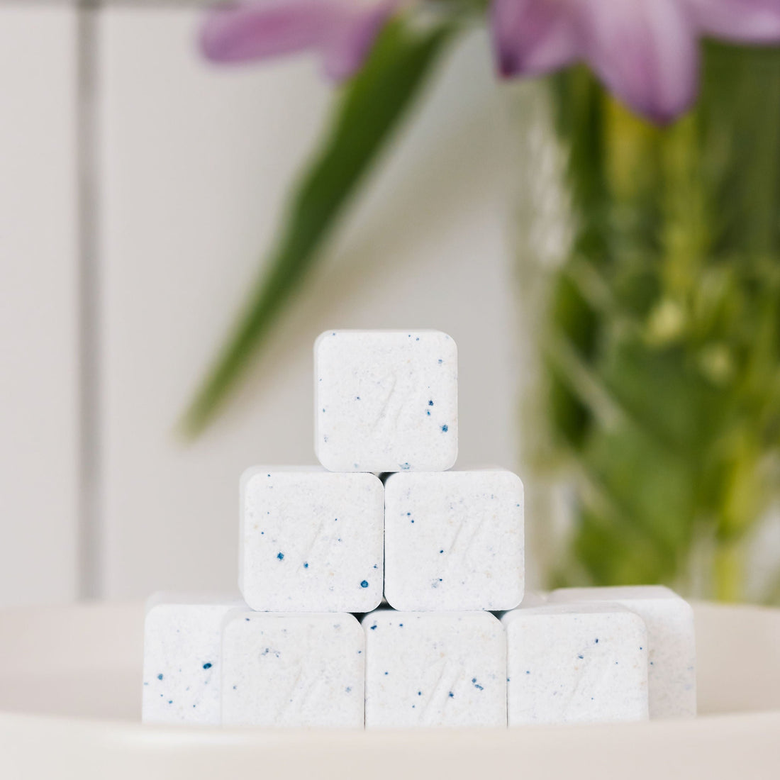 Stack of Nellie's Dish Cube on a light surface with blurred greenery in the background